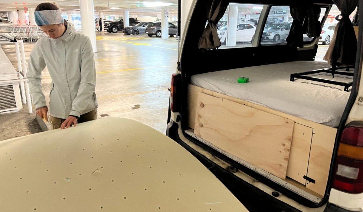 Bei Ikea kauften wir eine 1,40 m große Schaummatratze. Die restlichen 10 cm, die bei der Breite des Autos fehlen, stopften wir mit einem abgeschnittenen Streifen der alten Matratze. Außerdem nutzten wir einen Streifen als Lehne für die Gemütlichkeit im Bett.